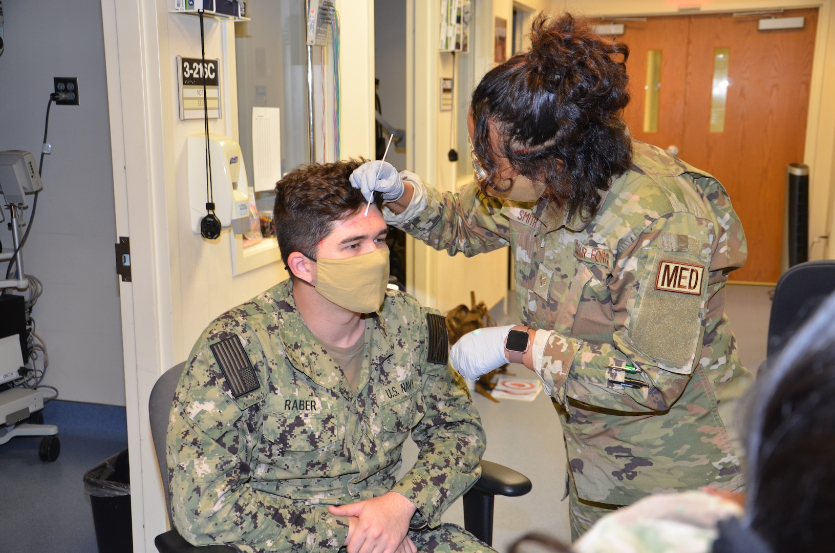 Air Force Senior Airman Christine Smith,  a student in the Neurodiagnostic Technician program at the Medical Education and Training Campus, practices the electrode application method required for performance of the Electroencephalogram (EEG) on fellow student, Navy Seaman Larry Raber.