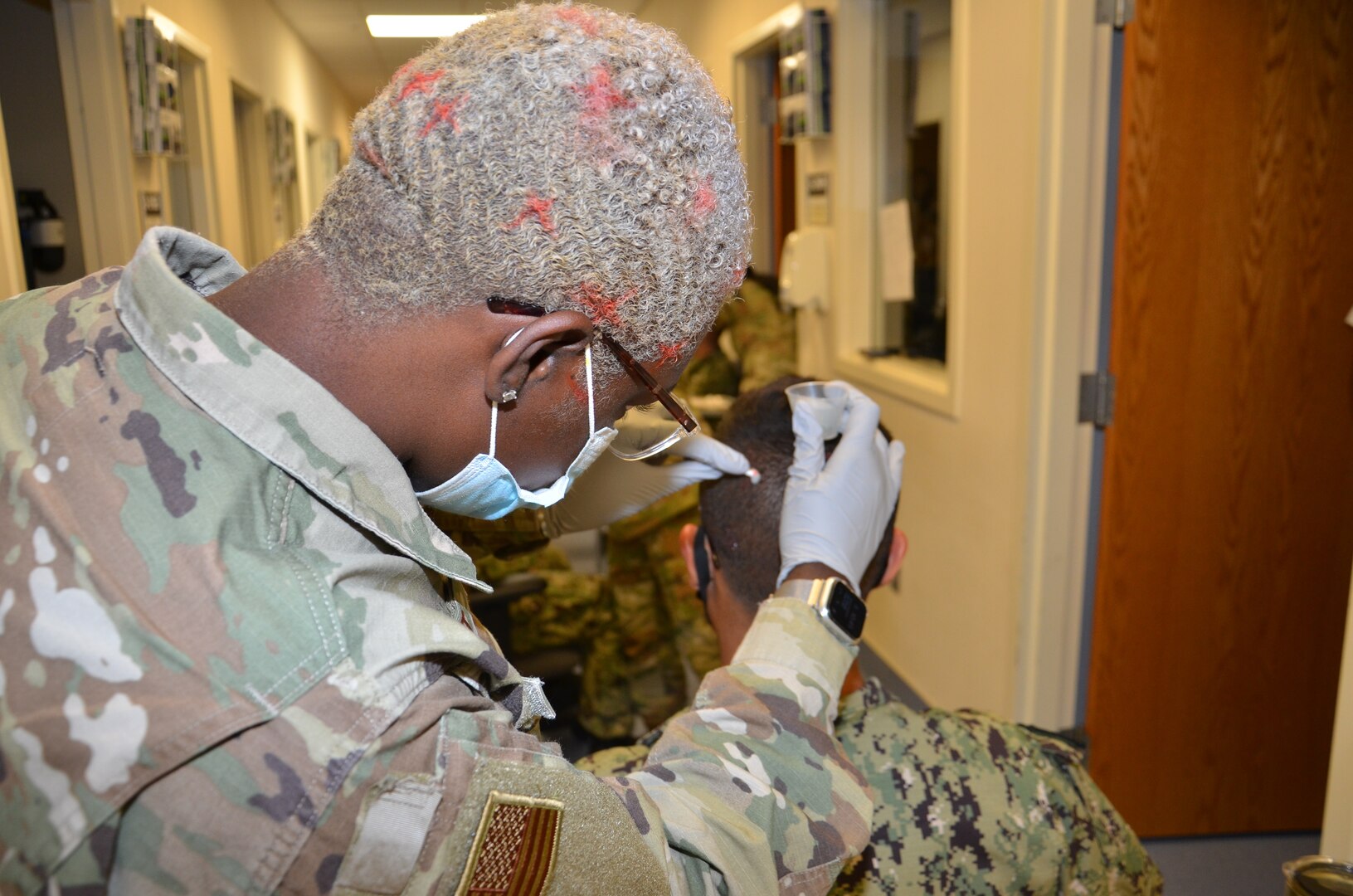Air Force Senior Airman Jamila Basit, a student in the Neurodiagnostic Technician program at the Medical Education and Training Campus, practices the electrode application method required for performance of the Electroencephalogram (EEG) on fellow student, Navy Seaman Marcus Falcon.