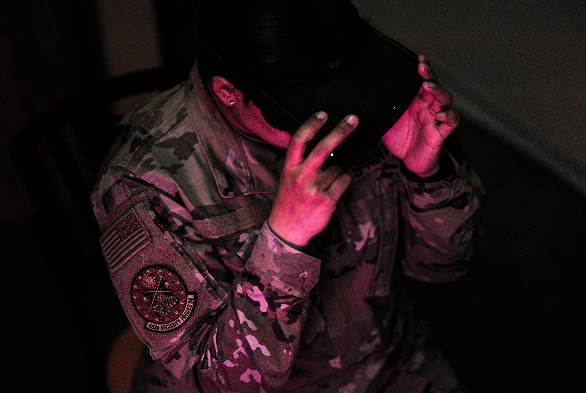 A 432nd Security Forces Squadron wears virtual reality goggles in the dark