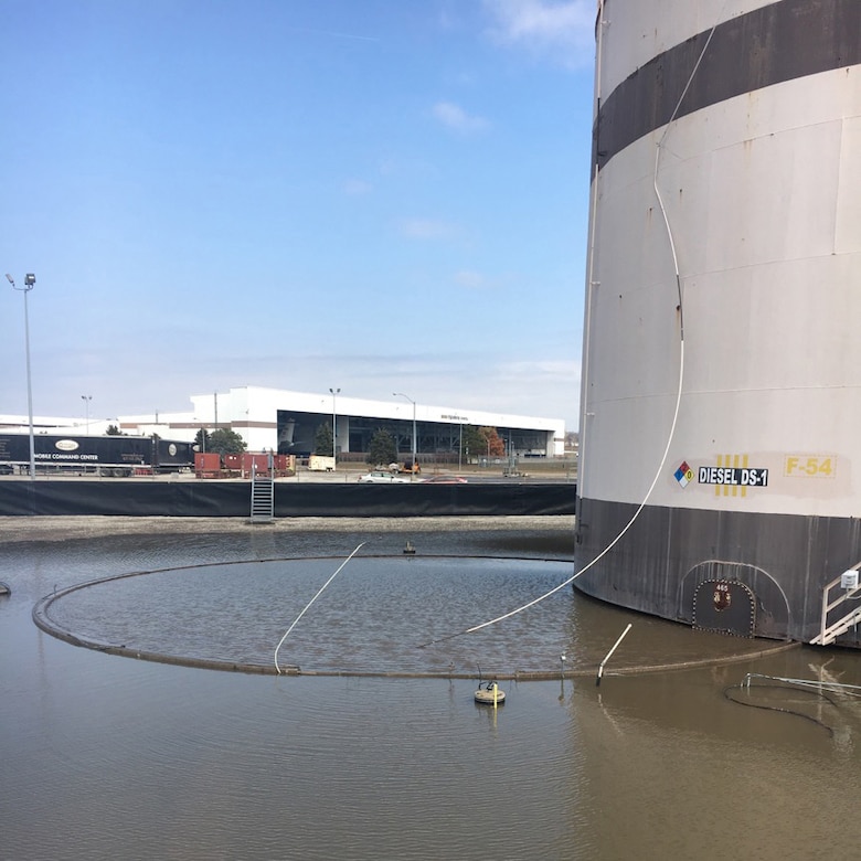 A tank and boom float in a body of water.