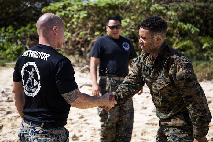 U.S. Marine Corps SSgt. Cole Lietha, left, a combat instructor of the Detachment Hawaii Enhanced Squad Leader Course, shakes hands with Sgt. Brandon Cooper, right, a student in the course, after grappling at the ground fighting station, one of twelve stations in the initial performance assessment portion of the course, Marine Corps Base Hawaii, April 8, 2021. The course is an experimental proof of concept, with the intent of modernizing training and providing squad leaders with new capabilities. (U.S. Marine Corps photo by Lance Cpl. Brandon Aultman)