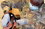 Air Force Senior Airman Jamila Basit, a student in the Neurodiagnostic Technician program at the Medical Education and Training Campus at Joint Base San Antonio-Fort Sam Houston, practices the electrode application method required for performance of the electroencephalogram, or EEG, on fellow student Navy Seaman Marcus Falcon.