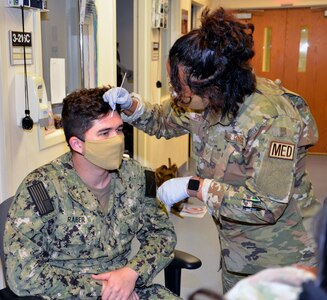 Air Force Senior Airman Christine Smith, a student in the Neurodiagnostic Technician program at the Medical Education and Training Campus at Joint Base San Antonio-Fort Sam Houston, practices the electrode application method required for performance of the enlectroencephalogram, or EEG, on fellow student Navy Seaman Larry Raber.