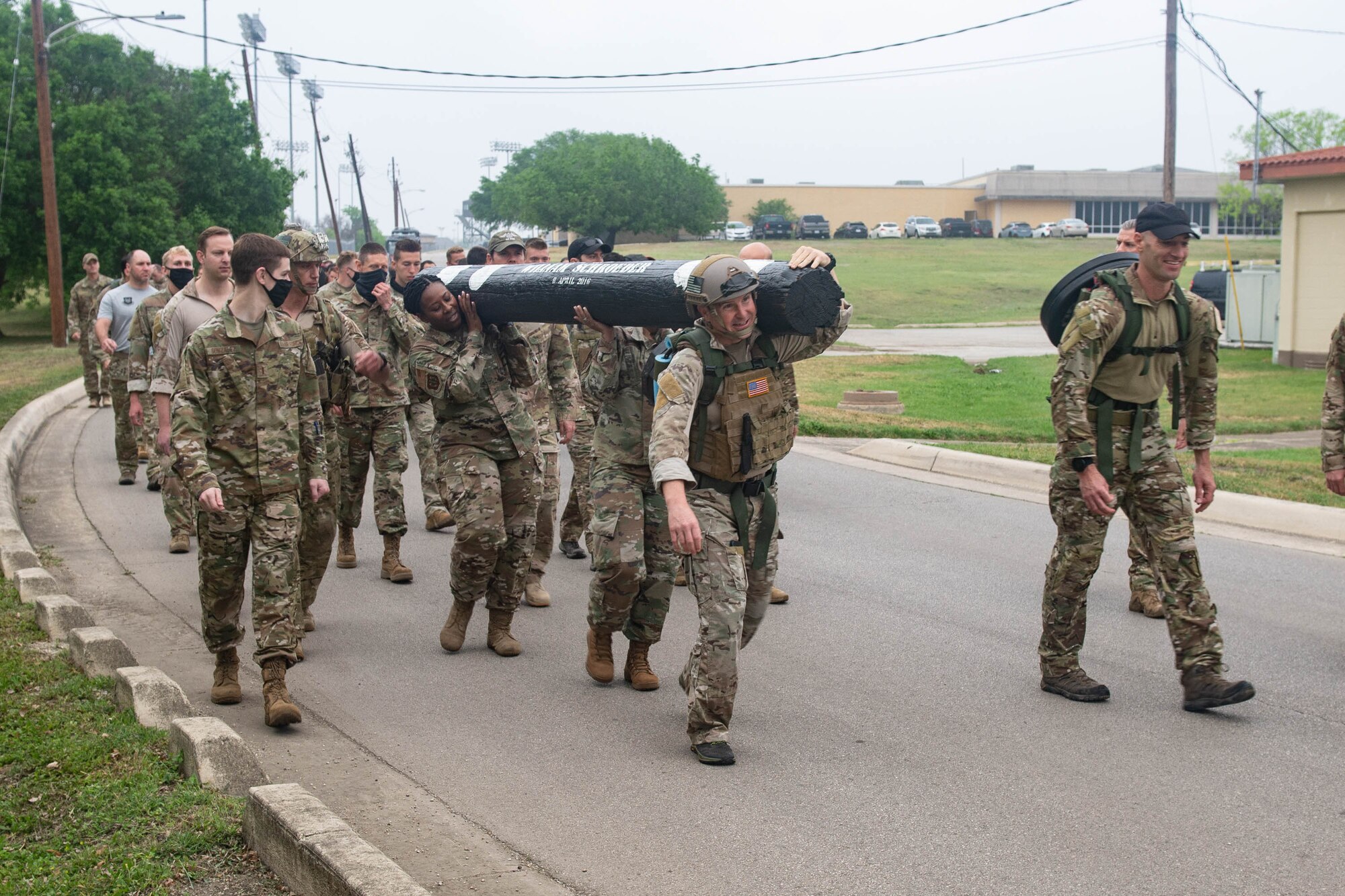 JOINT BASE SAN ANTONIO-CHAPMAN TRAINING ANNEX, Texas—Chief Master Sgt. Todd M. Popovic, Special Warfare Training Wing, or SWTW, command chief, leads a formation in memorial pushups after a memorial log carry for fallen airman, Lt. Col. William Schroeder, at the SWTW located on Joint Base San Antonio-Chapman Training Annex, or JBSA-CTA, Apr. 8, 2021.