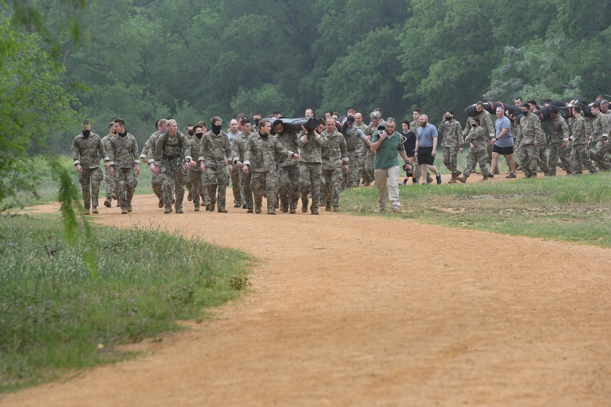 JOINT BASE SAN ANTONIO-CHAPMAN TRAINING ANNEX, Texas—Chief Master Sgt. Todd M. Popovic, Special Warfare Training Wing, or SWTW, command chief, leads a formation in memorial pushups after a memorial log carry for fallen airman, Lt. Col. William Schroeder, at the SWTW located on Joint Base San Antonio-Chapman Training Annex, or JBSA-CTA, Apr. 8, 2021.