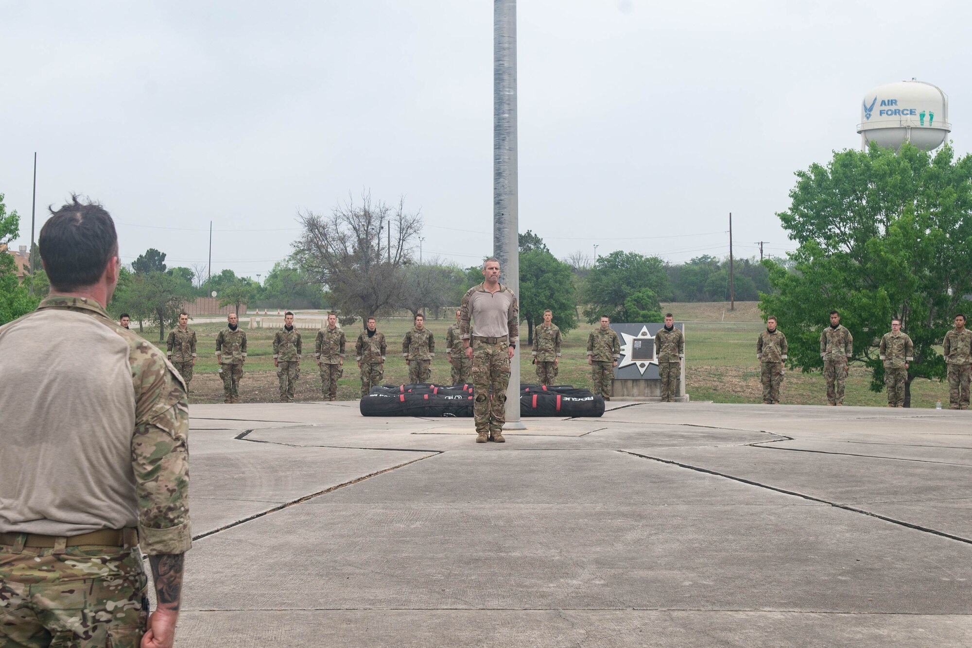 JOINT BASE SAN ANTONIO-CHAPMAN TRAINING ANNEX, Texas—Chief Master Sgt. Todd M. Popovic, Special Warfare Training Wing, or SWTW, command chief, leads a formation in memorial pushups after a memorial log carry for fallen airman, Lt. Col. William Schroeder, at the SWTW located on Joint Base San Antonio-Chapman Training Annex, or JBSA-CTA, Apr. 8, 2021.