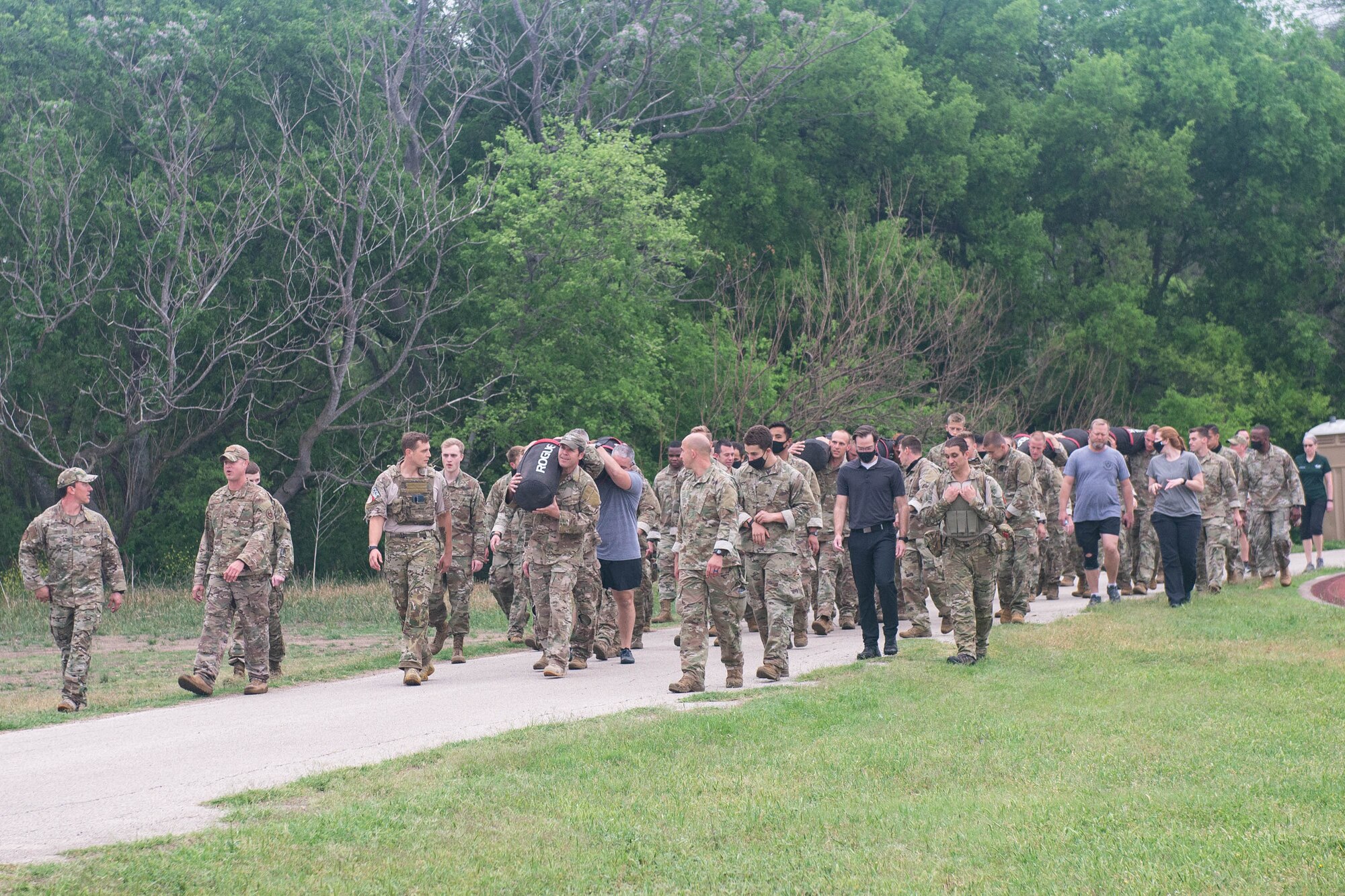 JOINT BASE SAN ANTONIO-CHAPMAN TRAINING ANNEX, Texas—Chief Master Sgt. Todd M. Popovic, Special Warfare Training Wing, or SWTW, command chief, leads a formation in memorial pushups after a memorial log carry for fallen airman, Lt. Col. William Schroeder, at the SWTW located on Joint Base San Antonio-Chapman Training Annex, or JBSA-CTA, Apr. 8, 2021.