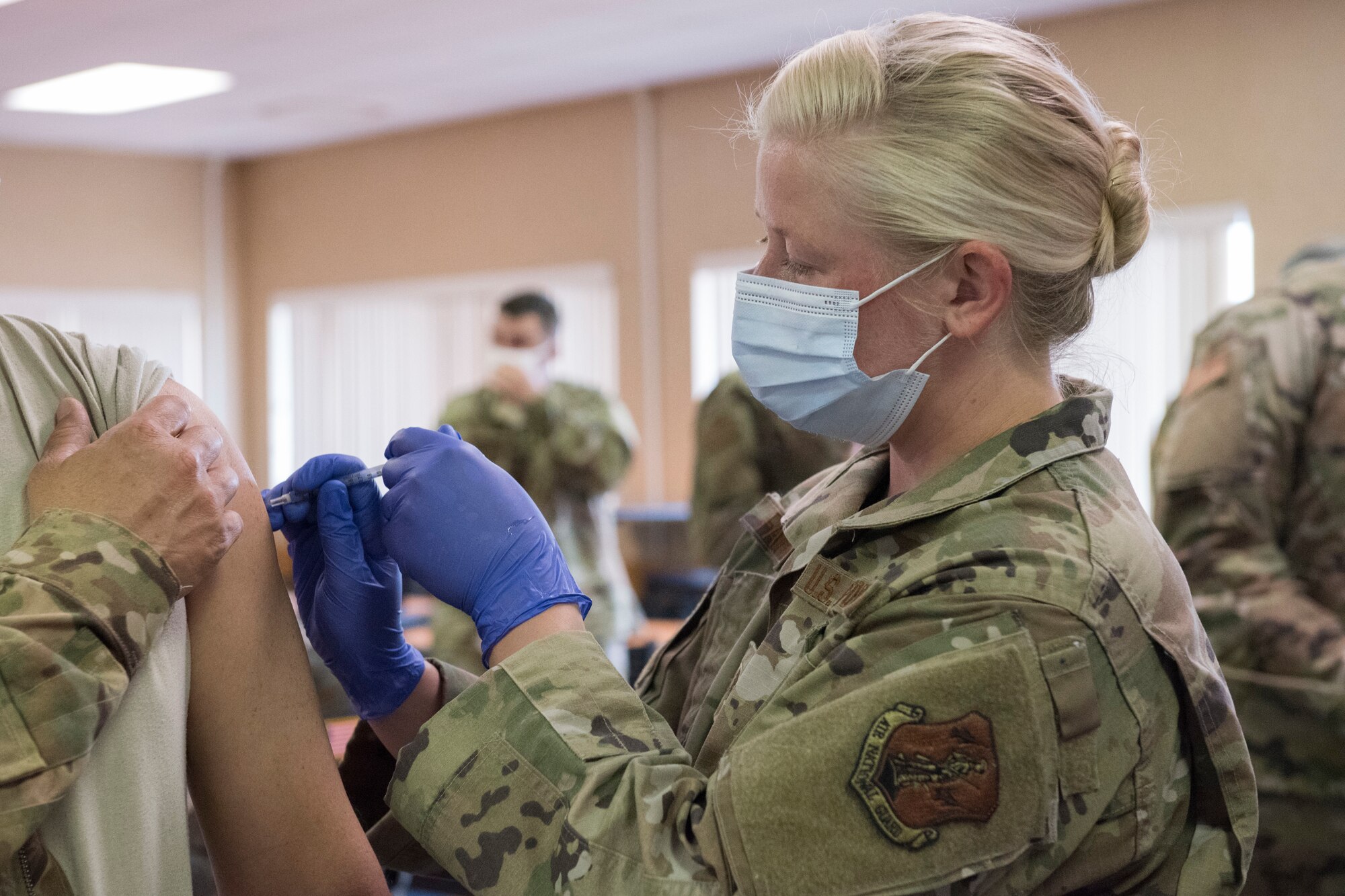 U.S. Air Force Staff Sgt. Katie Farrell, an aerospace medical technician with the 167th Medical Group assigned to the West Virginia National Guard’s Task Force Medical – East, administers a Pfizer COVID-19 vaccine to an Airman in the 167th Airlift Wing dining facility, Martinsburg, West Virginia, April 11, 2021. The vaccine is administered in two shots, with the second shot administered no more than six weeks after the first.
