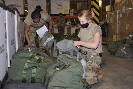 Tech Sgt. Alicia Garvin, 433rd Force Support Squadron customer support NCO in charge, Staff Sgt. Alexandra Thompson, 433rd FSS customer support assistant, and Staff Sgt. Taylor Mogford, 433rd Logistics Readiness Squadron individual protective equipment supervisor (background), prepare and issue equipment for an upcoming exercise at Joint Base San Antonio-Lackland, Texas, April 7, 2021. The 433rd LRS contains 120 Airmen in eight Air Force career fields, who specialize in deployment planning, supply chain operations, fuels and transportation management. (U.S. Air Force photo by Senior Airman Brittany Wich)