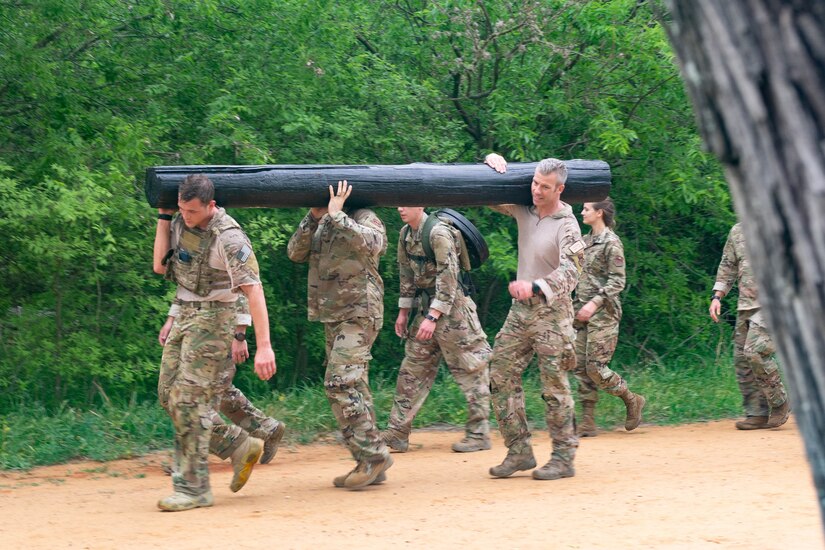 JOINT BASE SAN ANTONIO-CHAPMAN TRAINING ANNEX, Texas—Chief Master Sgt. Todd M. Popovic, Special Warfare Training Wing, or SWTW, command chief, leads a formation in memorial pushups after a memorial log carry for fallen airman, Lt. Col. William Schroeder, at the SWTW located on Joint Base San Antonio-Chapman Training Annex, or JBSA-CTA, Apr. 8, 2021.
