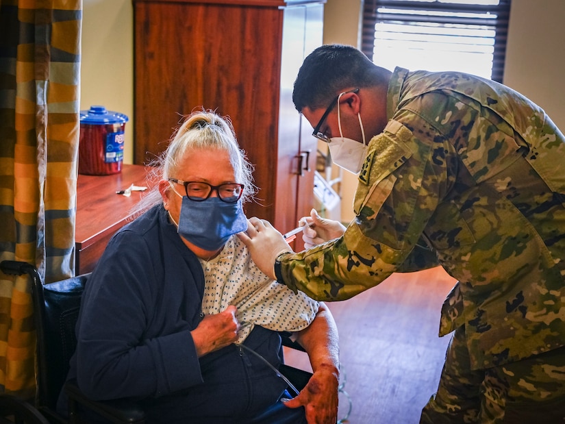 Spc. Andres Salgado, 142nd Medical Company combat medic, vaccinates Marilyn Degnan, a resident at the Mary Wade Home in New Haven, Connecticut, April 9, 2021. The Connecticut National Guard assisted the Connecticut Department of Public Health in providing COVID-19 vaccinations to nursing home residents and staff through “Operation Matchmaker.”