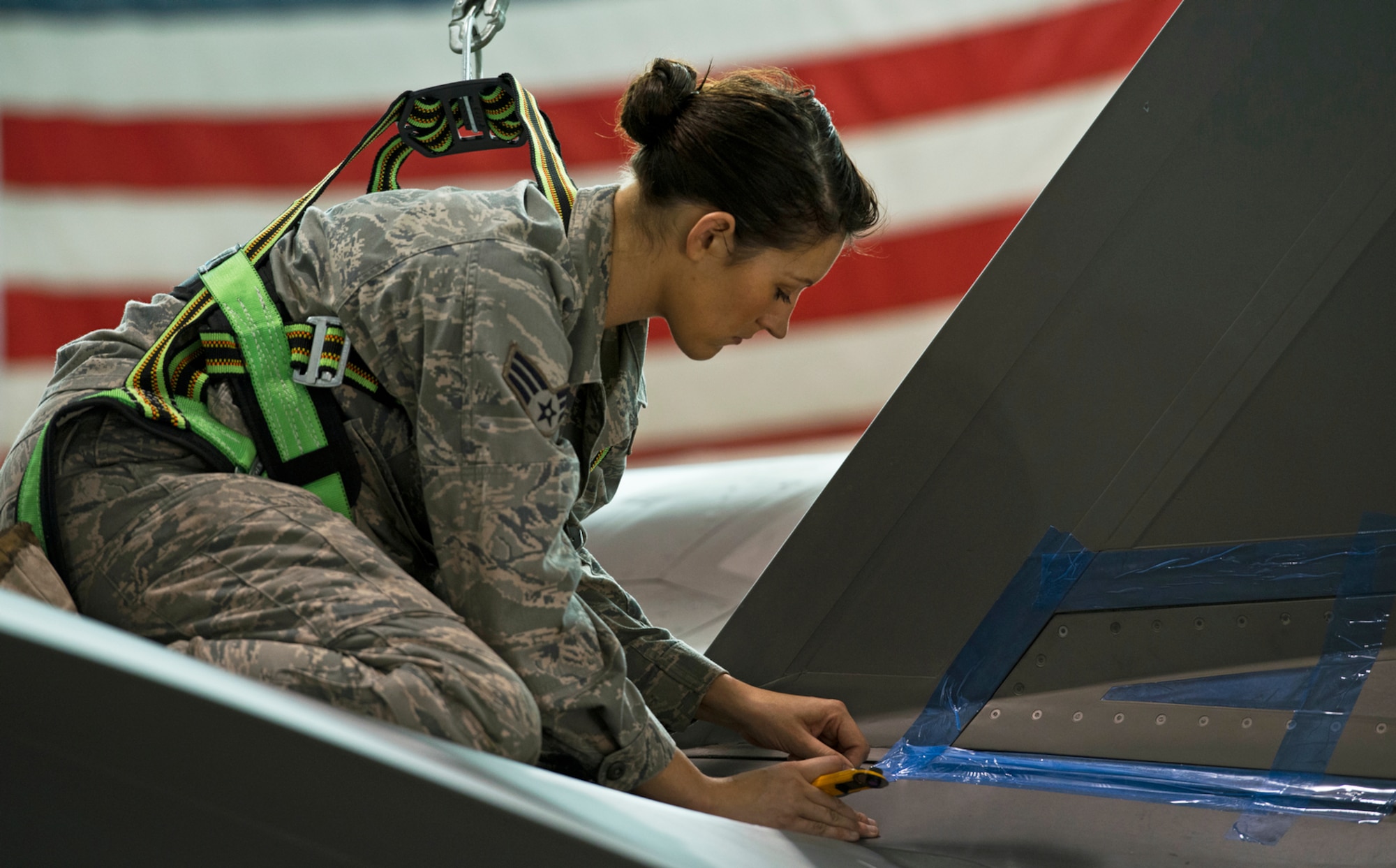 Senior Airman Jessa Fleming, a low observable technician, masks areas of an F-35 Lightning II in need of metal repair work. Fleming is responsible for maintaining the stealth characteristics of the Joint Strike Fighter. (U.S. Air Force photo/Tech. Sgt. Bennie J. Davis III)