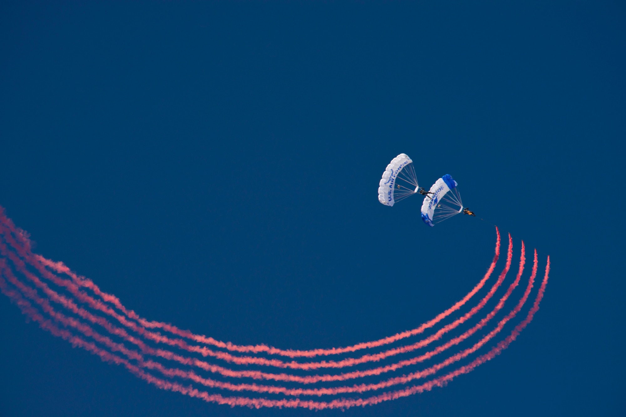 Members of the Wings of Blue Demonstration Team practice a double-stacked-smoke-chain jump above the U.S. Air Force Academy in Colorado Springs, Co. The Wings of Blue demonstration team performs at every home Air Force football game, various air shows throughout the nation, and other high profile venues. (U.S. Air Force photo/Tech. Sgt. Bennie J. Davis III)