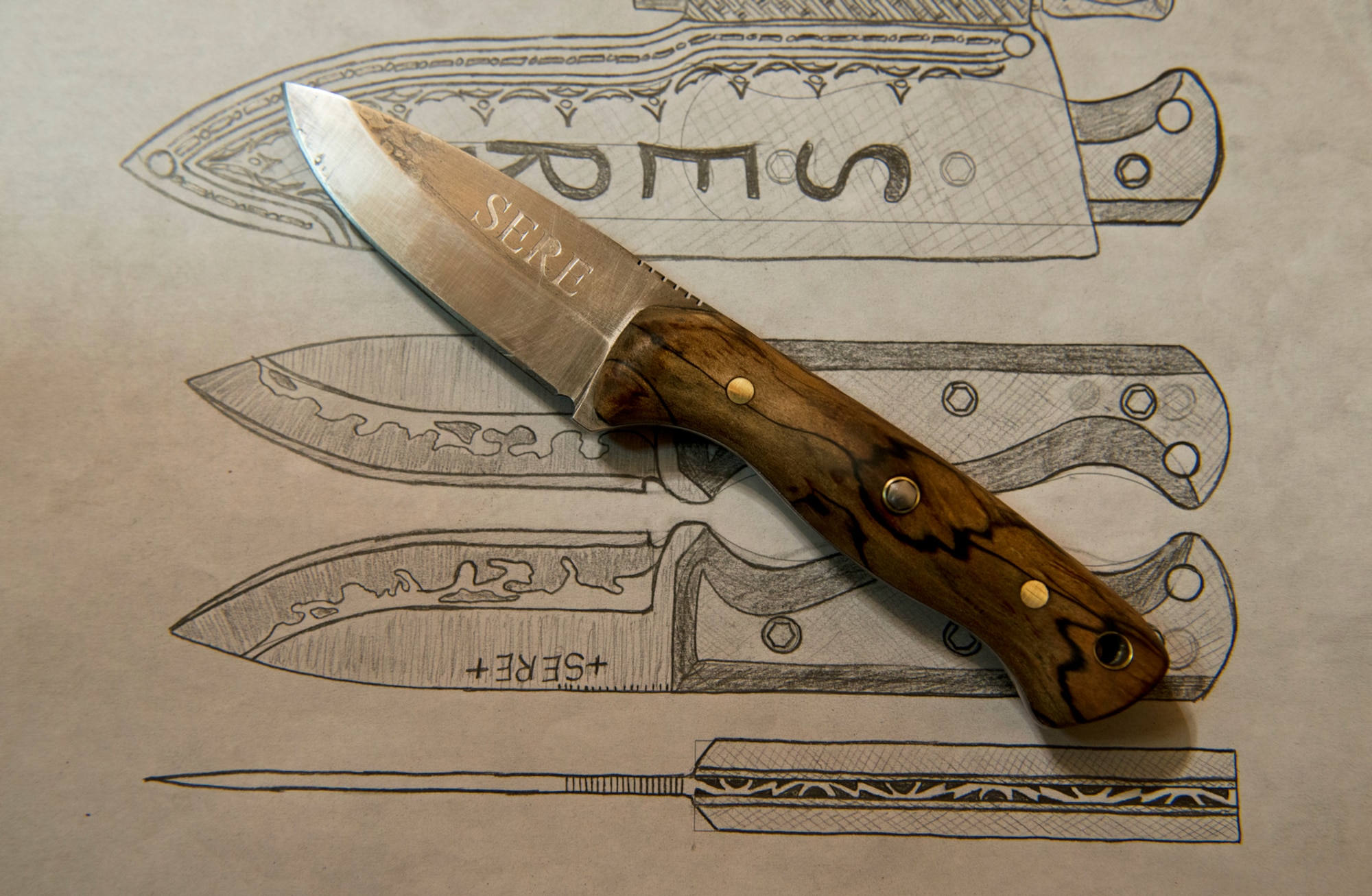 A completed survival, evasion, resistance and escape inspired custom knife by SERE instructor Senior Airman Joseph Collett. Collett likens the molding and shaping of steel in creating a knife with the same goal of SERE, to molding and shaping stronger Airman through survival training. (U.S. Air Force photo/Tech. Sgt. Bennie J. Davis III)