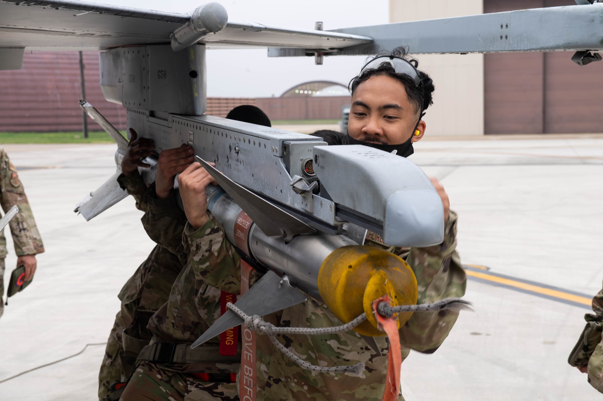 Senior Airman Ian Saure, 36th Aircraft Maintenance Unit load crew member, positions a munition during the Load Crew of the Quarter Competition at Osan Air Base, Republic of Korea, April 16, 2021. Two teams from the 36th and 25th Aircraft Maintenance Units raced to build and load munitions onto either the A-10 Thunderbolt II or the F-16 Fighting Falcon aircraft. (U.S. Air Force photo by Senior Airman Kevyn Allen)
