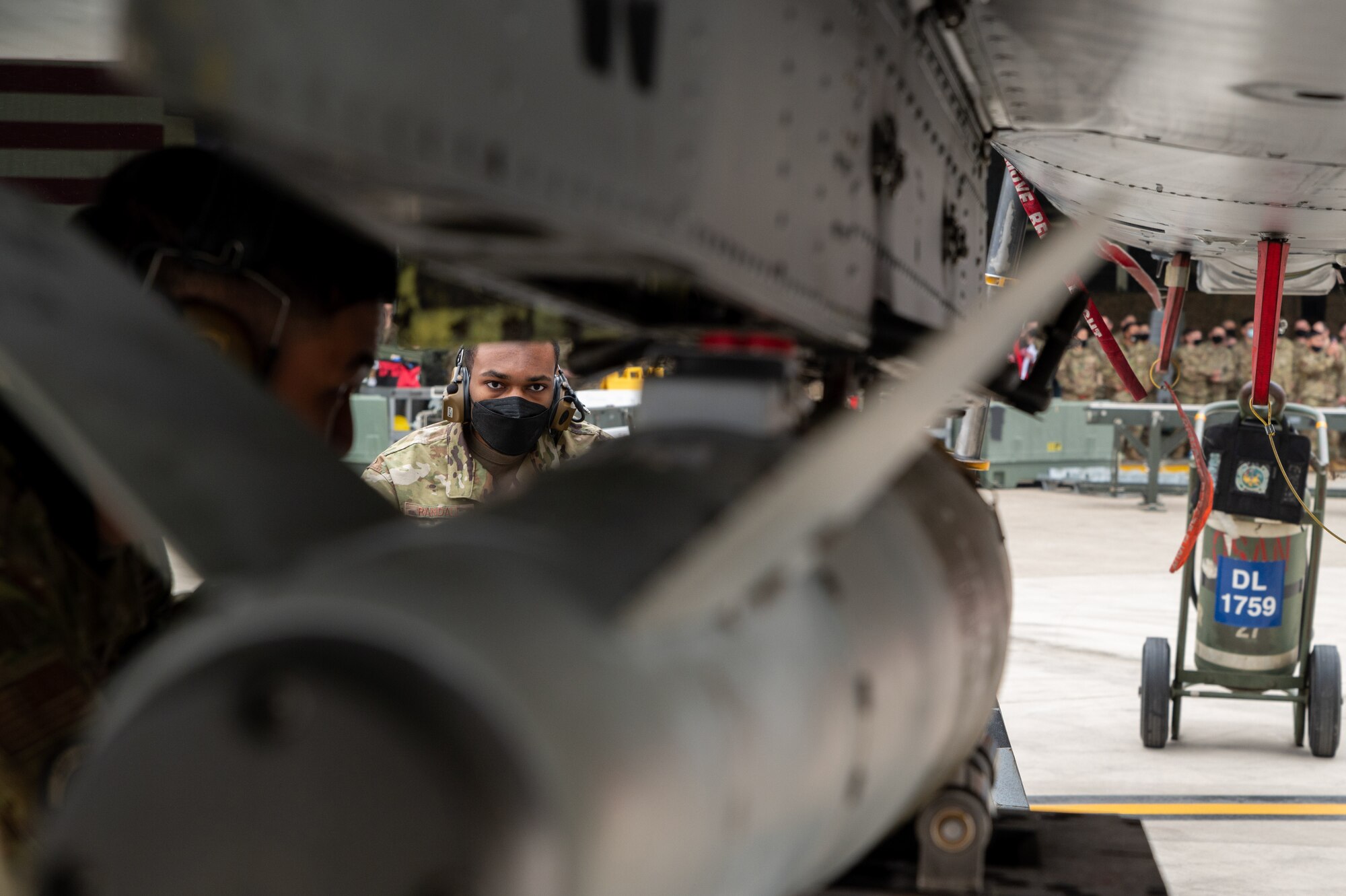 Senior Airman Keith Randall, 25th Aircraft Maintenance Unit load crew member, maneuvers munitions during the Load Crew of the Quarter Competition at Osan Air Base, Republic of Korea, April 16, 2021. The 51st Maintenance Group hosts a quarterly competition for teams to compete at building and loading munitions onto both the A-10 Thunderbolt II and F-16 Fighting Falcon aircraft. (U.S. Air Force photo by Technical Sgt. Nicholas Alder)