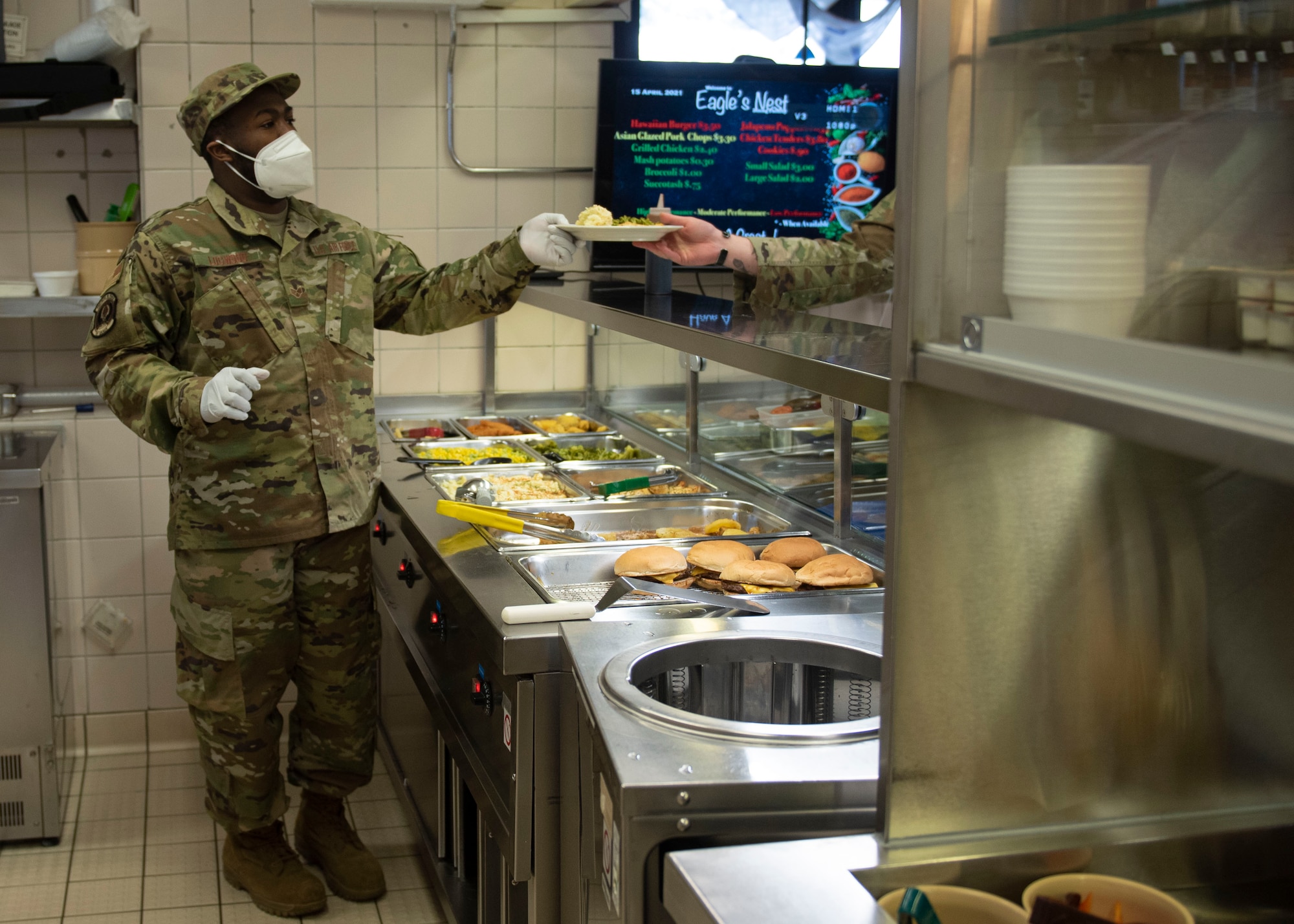 U.S. Air Force Senior Airman Andrew Logwood, 702nd Mission Support Flight dining facility storeroom manager, works the dining facility line, April 15, 2021, at the 702nd Munitions Support Squadron. The 702nd MSF Airmen recently won the Hennessy Award, which recognizes food handling excellence amongst Air Force dining facilities. (U.S. Air Force photo by Senior Airman Melody W. Howley)