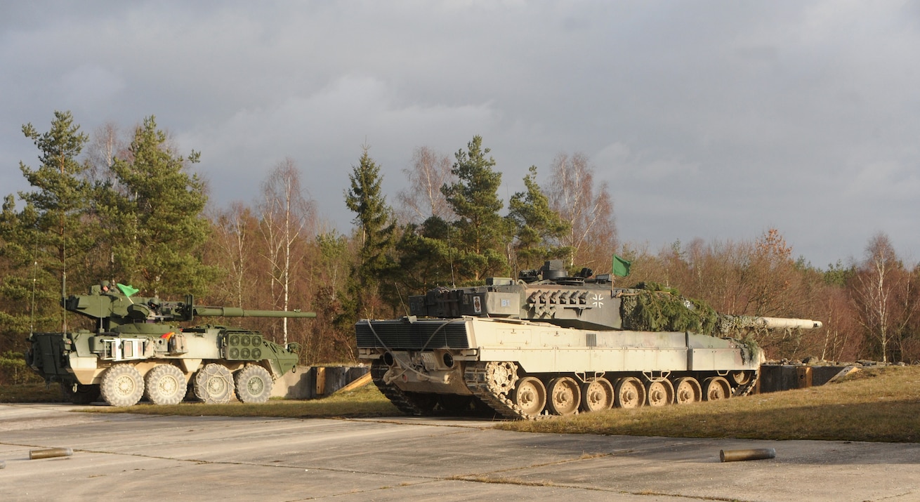 A U.S. Army Stryker Mobile Gun System vehicle and a German Bundeswehr Leopard 2 tank sit next to each other on the firing line in the Grafenwoehr Training Area during Operation Iron Panzer Dec. 8, 2011.