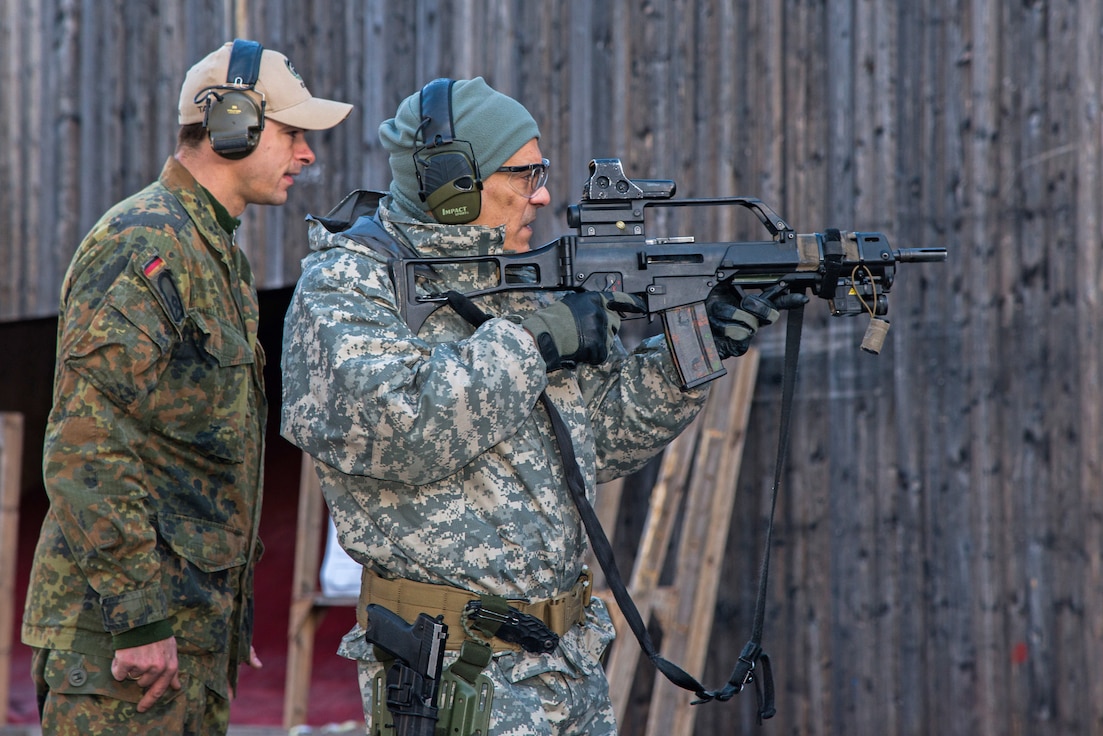 A German soldier (left) from the 2nd Company, Airborne Battalion 313 instructs a U.S. Army soldier from Special Operation Command as he fires Heckler & Koch G36 assault rifle from a standing firing position during his attempt to qualify for the German Schutzenschnur, the German Armed Forces Badge for Weapons Proficiency at a German/American partnership event at the Panzer Range Complex in Boeblingen, Germany.
