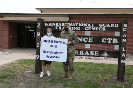 Maj. Michael Billings, Kansas Training Center battalion executive officer, and Hayley Samford, marketing and community outreach associate with the Salina Family Healthcare Center, advertise the COVID-19 vaccine clinic held at the Kansas National Guard Training Center April 15, 2021. The clinic teamed with the Kansas Guard because of the ideal location of its facilities to serve the west side of town.