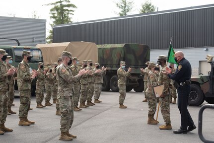 Staff Sgt. Dantè Davis, a military policeman with the 237th Military Police Company supporting the COVID-19 relief mission, receives an Army Achievement Medal and recognition during a ceremony April 11, 2021, at the New Hampshire National Guard Army Pembroke Regional Training Institute in Pembroke, New Hampshire. Davis called 911 and assisted a police officer in a violent encounter with a civilian driver on his commute home.