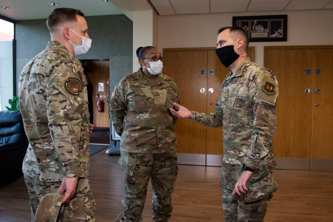U.S. Air Force Chief Master Sgt. Brion Blais, right, U.S. Air Forces in Europe and Air Forces Africa command chief, talks with Maj. James Holstein, left, 423rd Medical Squadron administrator, and Master Sgt. Vandora Cooper, center, 423rd MDS TRICARE operations and patient administration chief, during a visit to the COVID vaccination clinic at Royal Air Force Alconbury, England, April. 15, 2021. The USAFE-AFAFRICA command team visited the 501st CSW to engage with Airmen and recognize outstanding performers. (U.S. Air Force photo by Senior Airman Jennifer Zima)