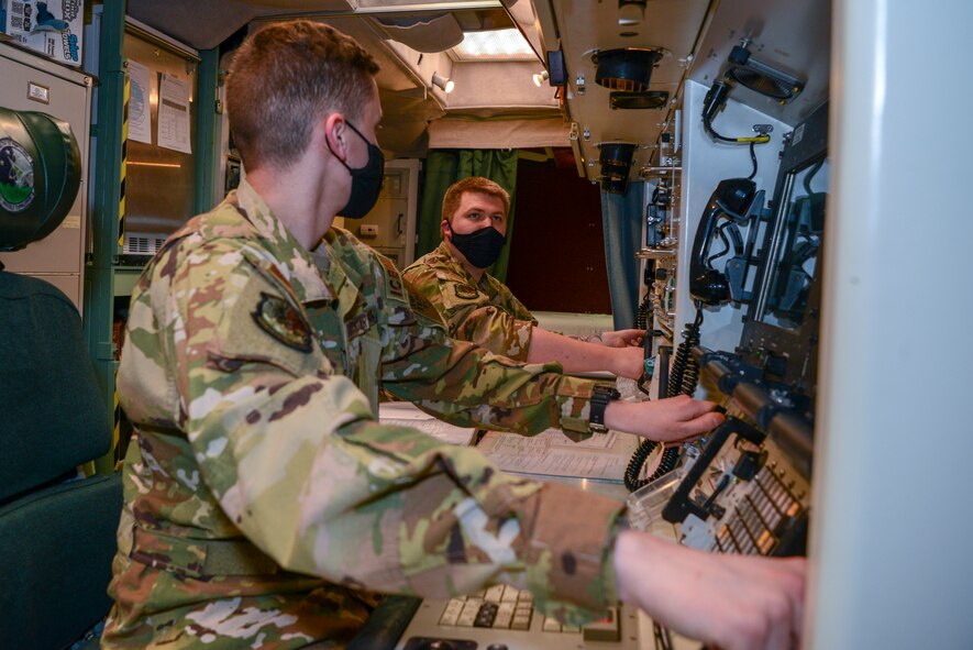 Two 91st Airman pose for a photo inside of a launch control center