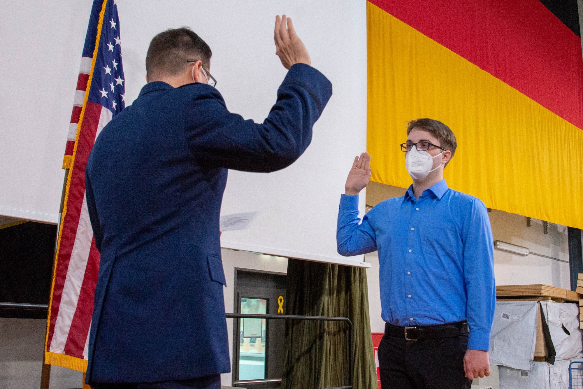 two people with their right hands raised in an oath ceremony