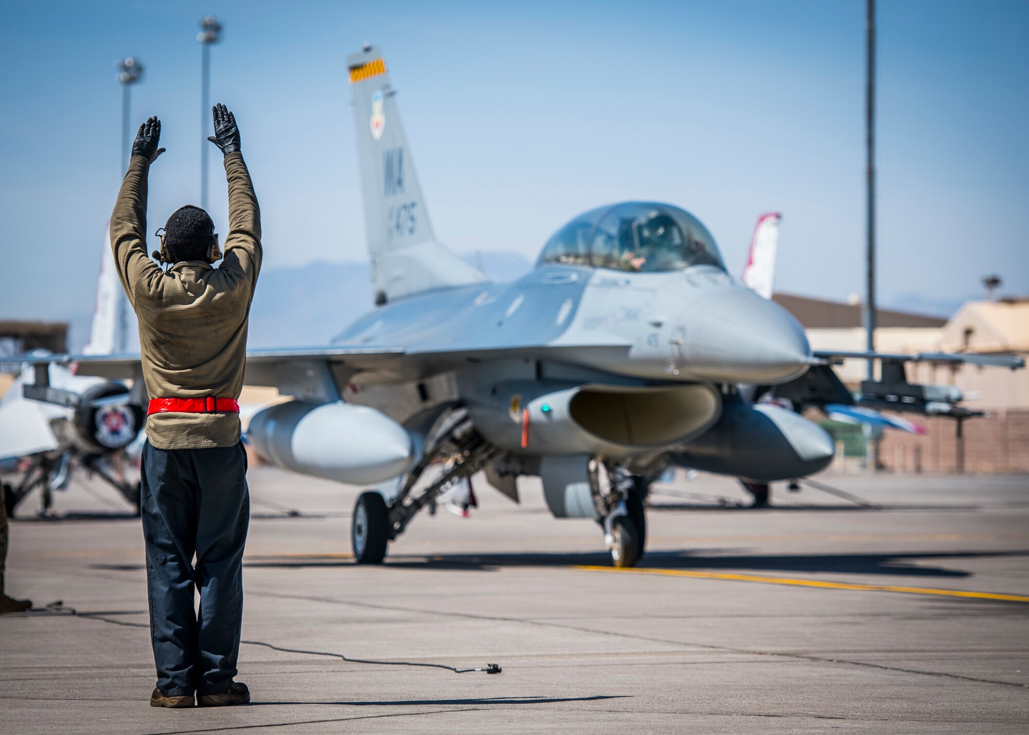 Senior Airman Lamont Cooper, 926th Aircraft Maintenance Squadron crew chief marshalls in  during a training exercise, April 10, 2021 at Nellis Air Force Base, Nev. The 926th AMXS conducted an operations exercise to maintain steadfast readiness that relate to real world day-to-day functions.