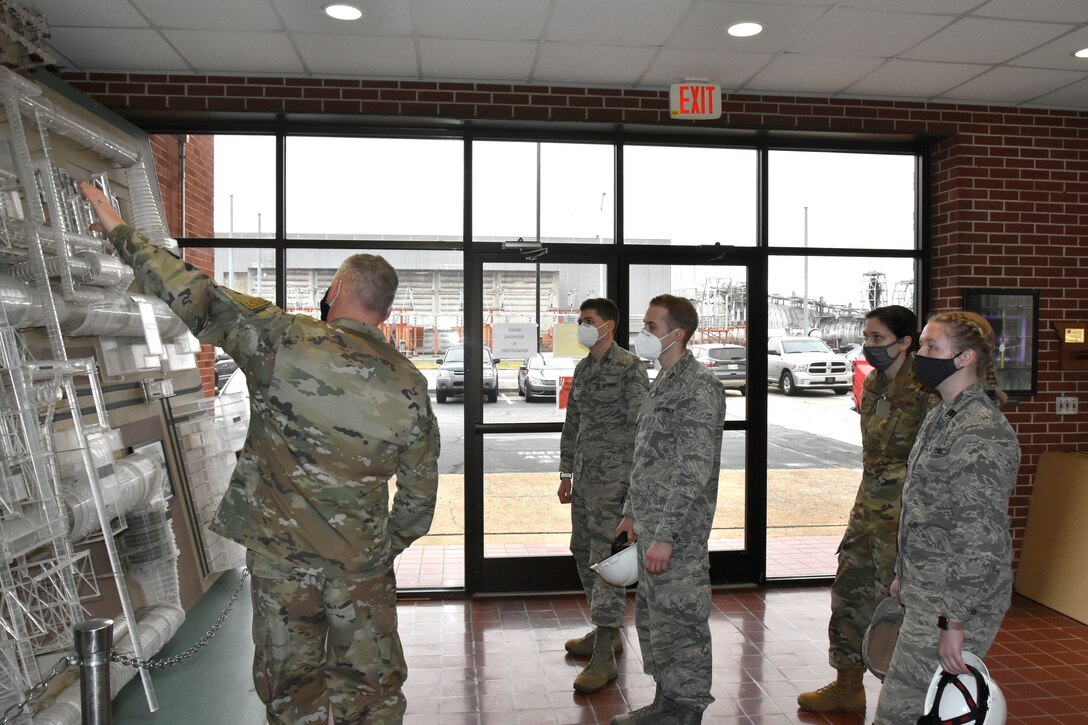 Capt. Michael Herbert, test manager in the Arnold Engineering Development Complex Aerodynamics Test Branch at Arnold Air Force Base, shows cadets with Air Force ROTC Detachment 290 from the University of Kentucky a model of the Propulsion Wind Tunnel at Arnold, March 19, 2021. The cadets, pictured from left, are Dominick Herbert, Andrew Kauffman, Dillyn Twisdale and Olivia Liddle. (U.S. Air Force photo by Bradley Hicks) (This image was altered by obscuring badges for security purposes.)