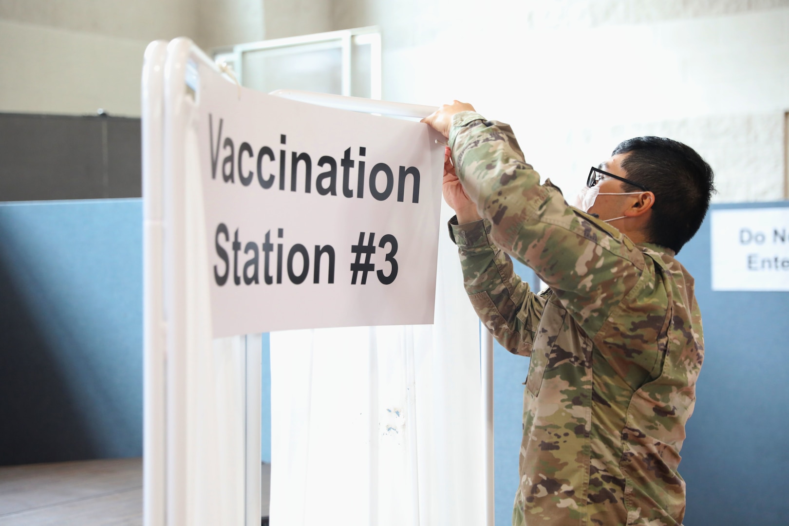 Service member takes down COVID-19 vaccination station signage