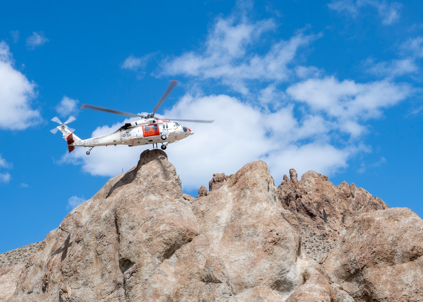 An MH-60S Knighthawk helicopter, assigned to the "Longhorns" of Helicopter Search and Rescue (SAR) Squadron, conducts a one wheel during a simulated SAR training exercise.
