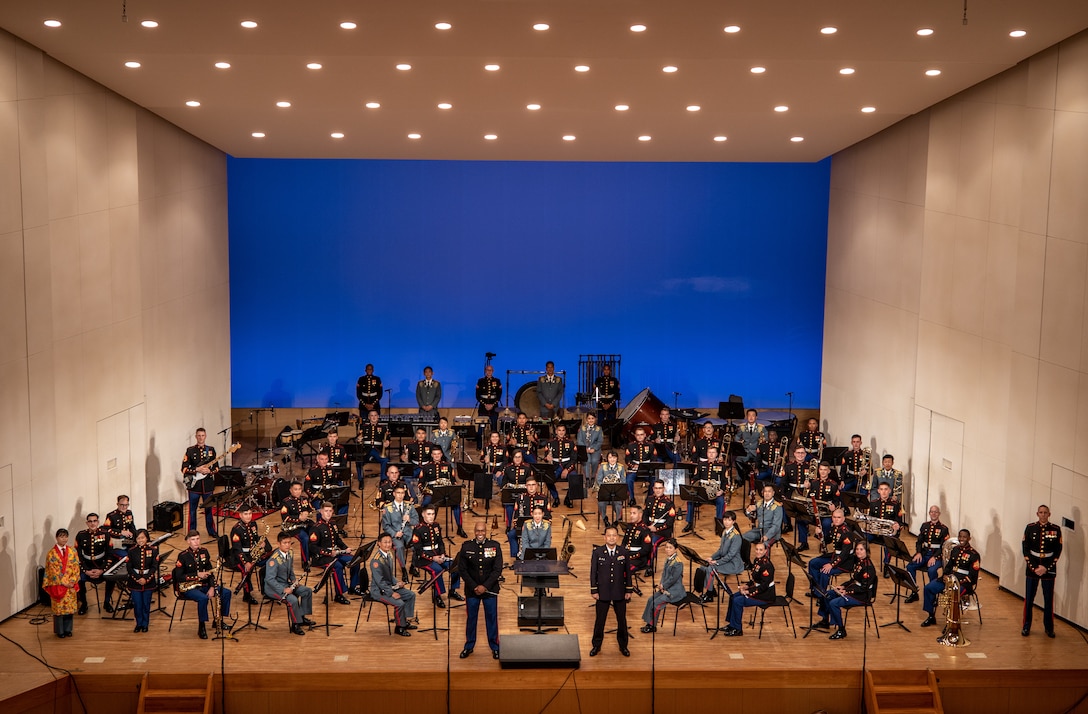 U.S. Marines with the III Marine Expeditionary Force and members of the Japan Ground-Self Defense Force 15th Brigade bands pose for a photo at Tedako Hall in Urasoe, Okinawa, Japan, April 16, 2021. The bands' harmonious performance was a display of the III MEF and 15th Brigade bands' alliance and unity within the musical arts. The annual concert was performed virtually and the recording will debut on social media platforms within the coming weeks.