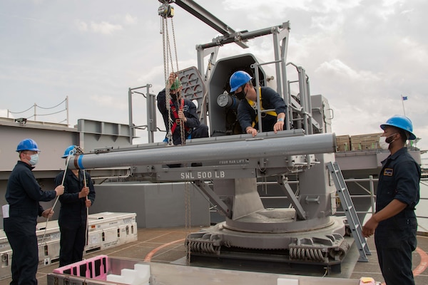 Sailors assigned to USS Gerald R. Ford (CVN 78) prepare to load a RIM 116 Block missile into a rolling airframe missile launcher during an ammunition onload.