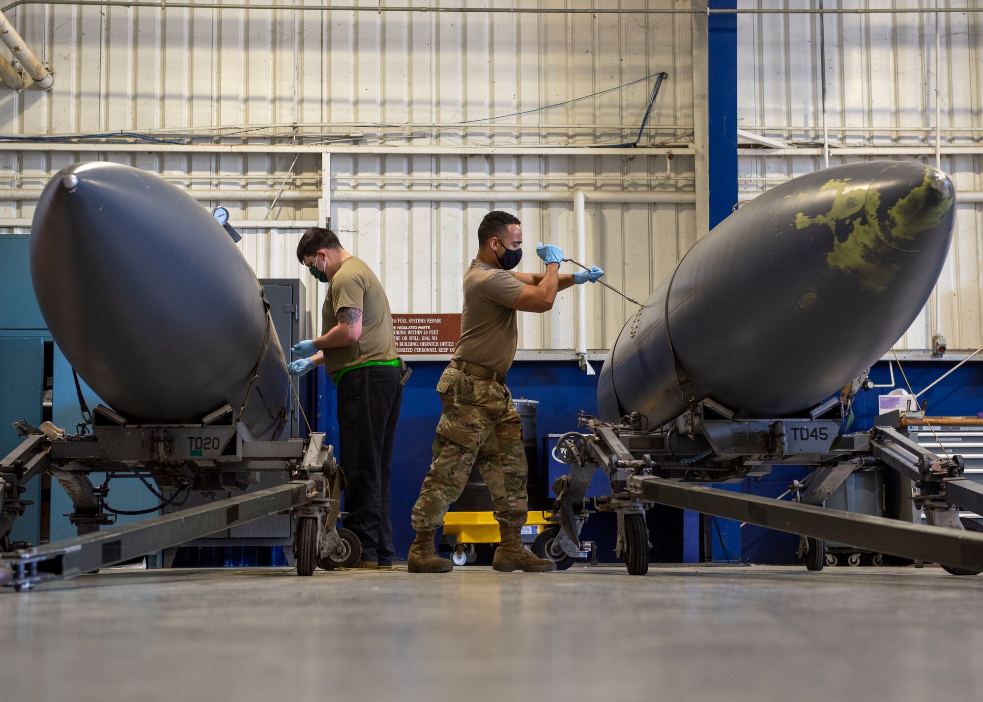 Senior Airman Donovan Bigelow, left, and Senior Airman Jevon Benjamin, 4th Component Maintenance Squadron fuels systems technicians, perform inspections on external fuel tanks at Seymour Johnson Air Force Base, North Carolina, April 13, 2021.