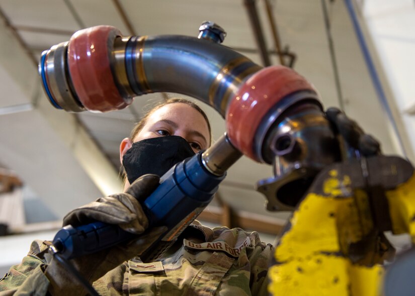 Senior Airman Elizabeth Zanath, 4th Component Maintenance Squadron fuels systems technician, heat-shrinks an engine-to-airframe manifold at Seymour Johnson Air Force Base, North Carolina, April 13, 2021.