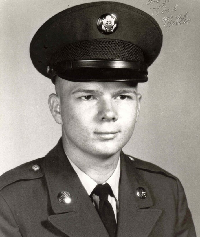 A young man in uniform and cap looks at the camera.