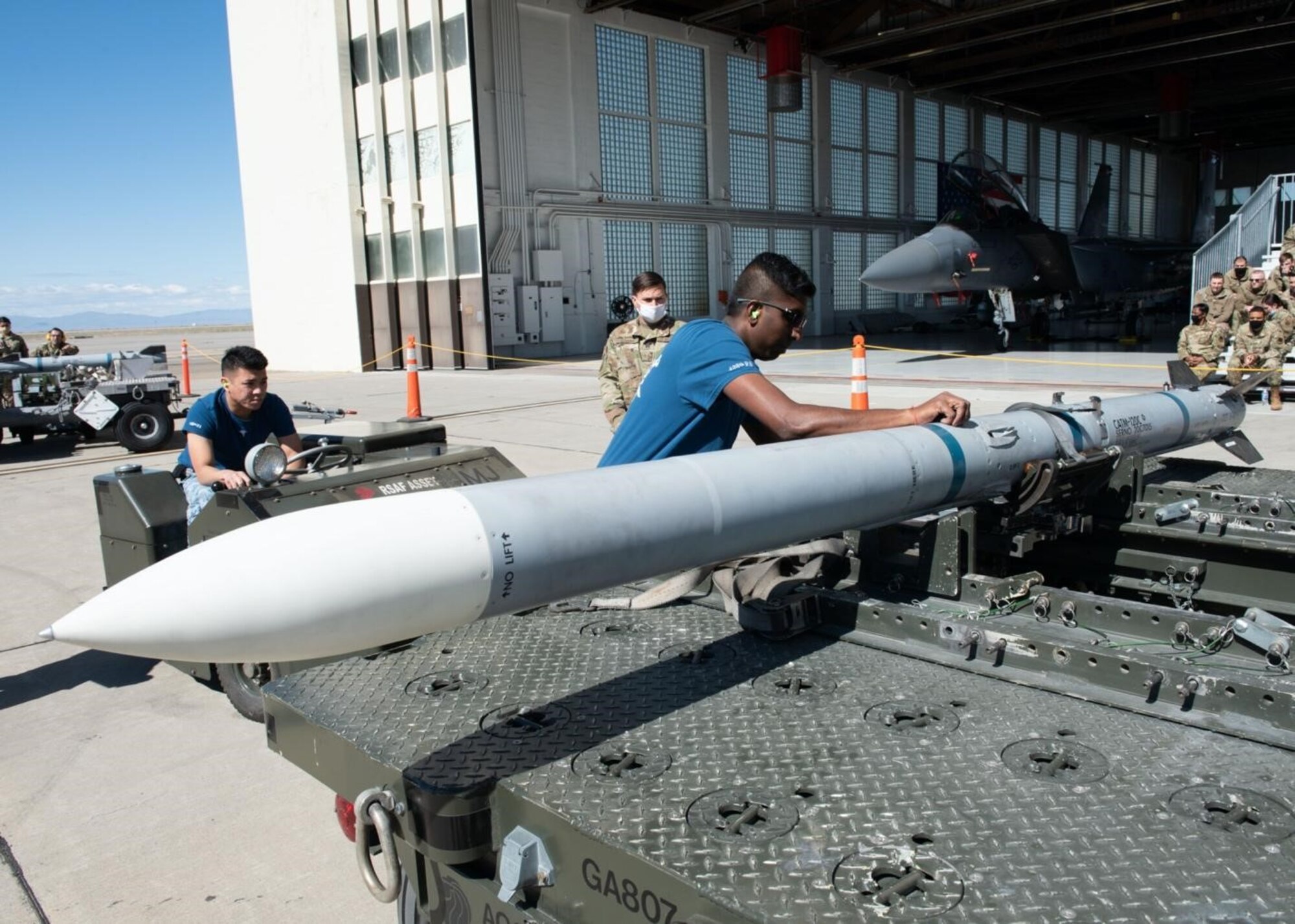 A Airman from the Republic of Singapore Air Force removes straps off an Air Intercept Missile.