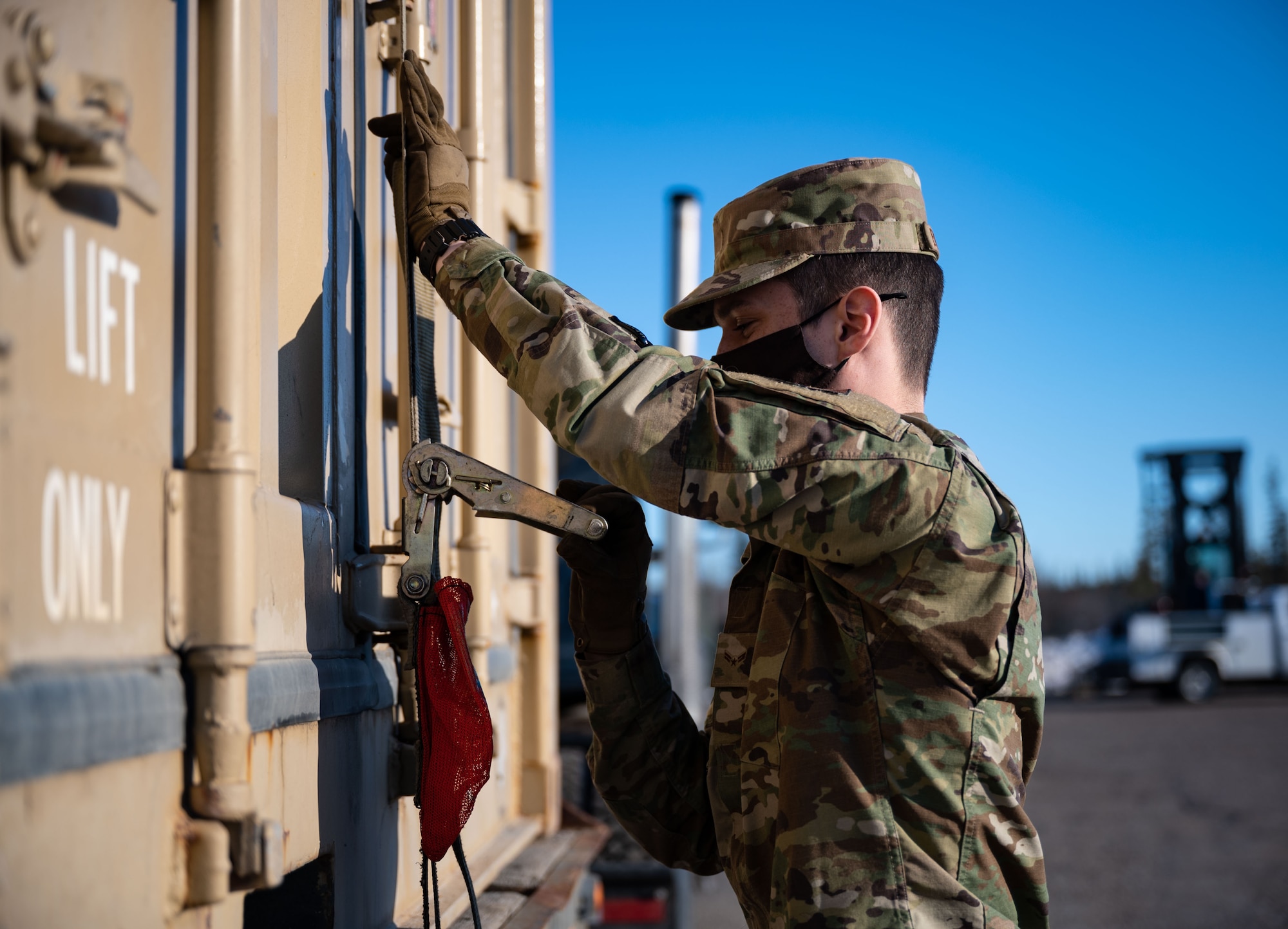 U.S. Air Force Airman 1st Class Mathew Bickford, a 354th Logistics Readiness Squadron ground transportation operator, secures a container during a munitions barge at Eielson Air Force Base, Alaska, April 16, 2021.