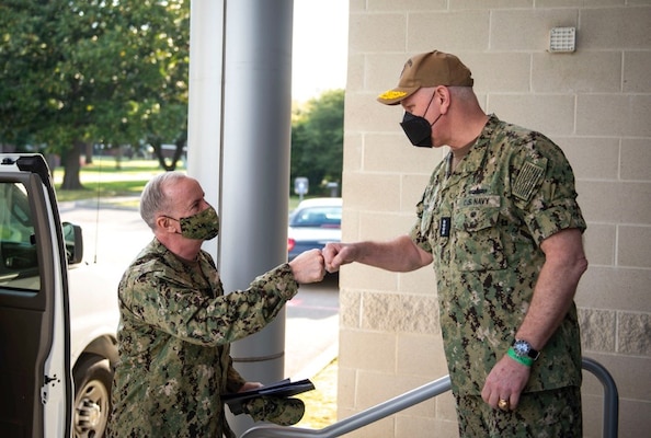 Admiral Bill Lescher, U.S. Navy Vice Chief of Naval Operations, center, is greeted by Rear Adm. Charles W. Rock, commander, Navy Region Mid-Atlantic, before a tour of unaccompanied Sailor housing during a trip to Hampton Roads, April 19, 2021. Lescher visited multiple commands in the Hampton Roads area, including U.S. Fleet Forces Command, Navy Region Mid-Atlantic, Military Sealift Command, Norfolk Naval Ship Yard, and Newport News Shipbuilding.
