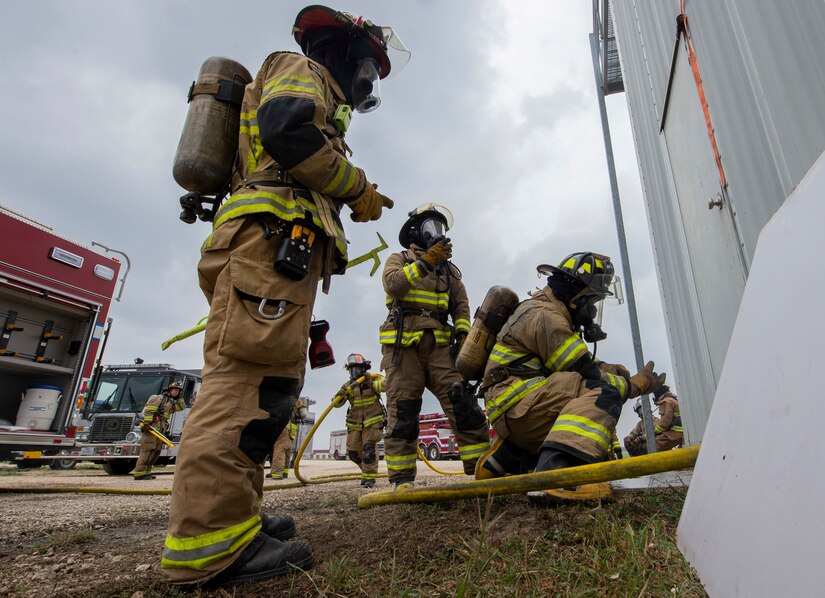 Firefighters from Cibolo Fire Department don gear before responding to a live fire training exercise, April 14, 2021, at Joint Base San Antonio-Randolph, Texas.