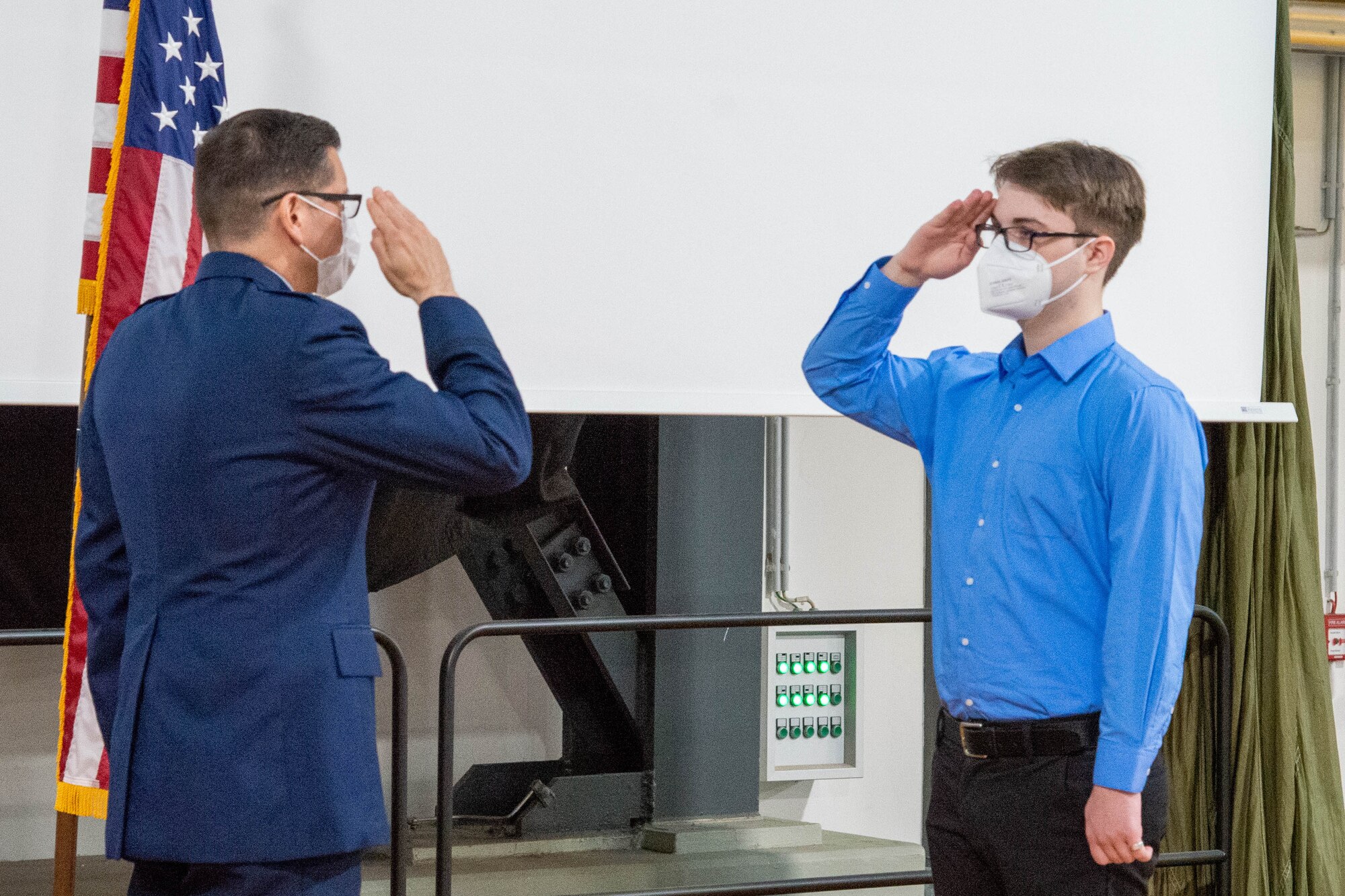 Two people salute each other.
