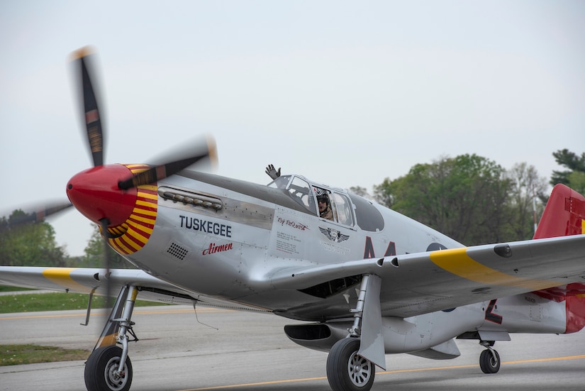 The pilot of a P-51 Red Tail waves while taxiing at Bowman Field following an aerial demonstration for the Thunder Over Louisville air show in Louisville, Ky., April 17, 2021. This year's event featured aircraft from multiple military and civilian agencies. (U.S. Air National Guard photo by Staff Sgt. Clayton Wear)