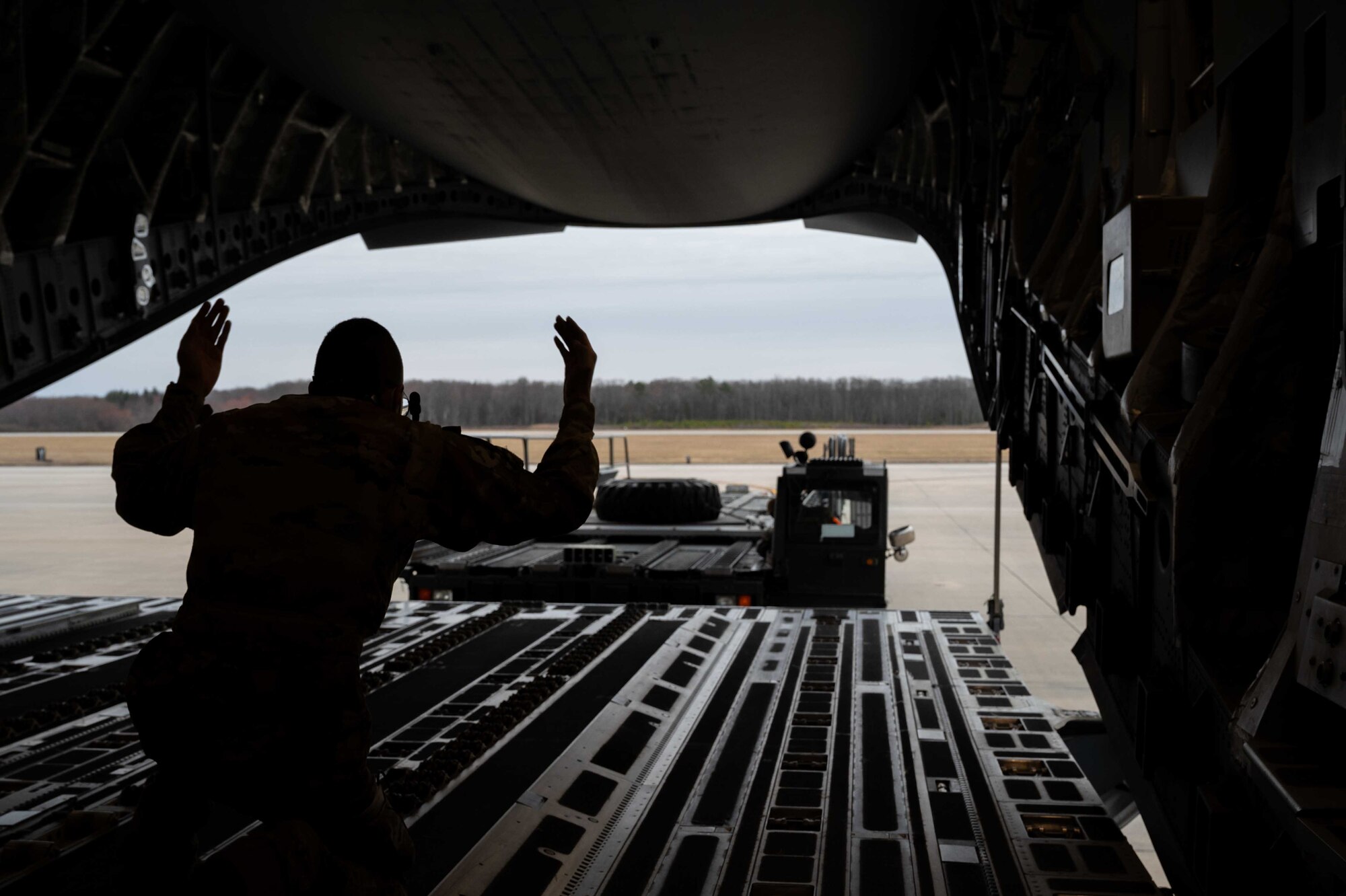 Airman 1st Class Jaymin Gilbert, 3rd Airlift Squadron loadmaster, marshals a K-loader to the ramp of a C-17 Globemaster III at Dover Air Force Base, Delaware, March 16, 2021. The 3rd AS constantly trains to provide global reach with unique, outsized and oversized airlift capability. (U.S. Air Force photo by Airman 1st Class Faith Schaefer)