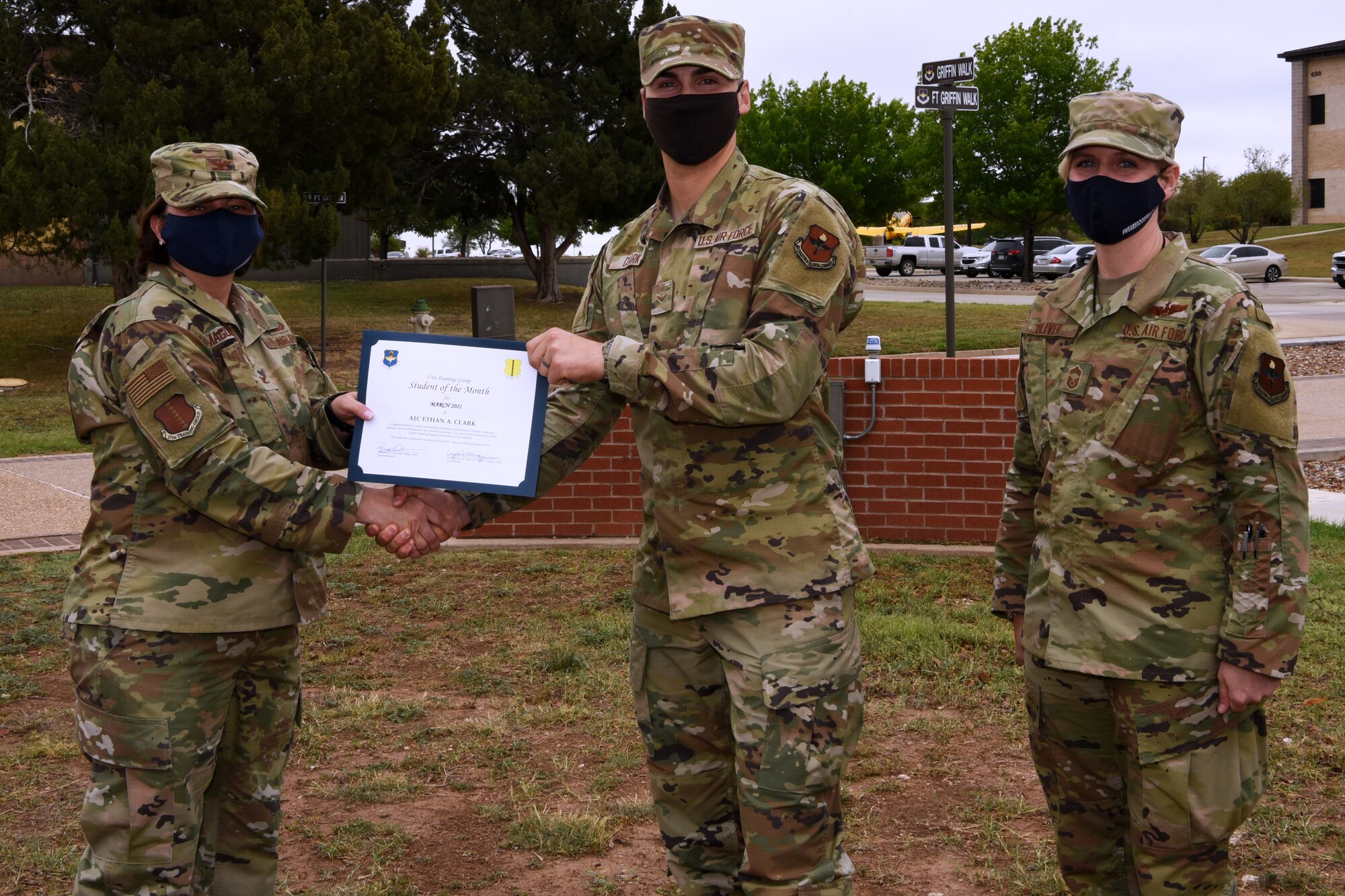 U.S. Air Force Col. Angelina Maguinness, 17th Training Group commander, presents Airman 1st Class Ethan Clark, 312th Training Squadron student, the 17th TRG Student of the Month award for March 2021, outside of the Brandenburg Hall on Goodfellow Air Force Base, Texas, April 16, 2021. The 312th TRS’s mission is to train, develop, and inspire warriors to deliver Fire Emergency Services and Nuclear Treaty Monitoring for the Department of Defense. (U.S. Air Force photo by Senior Airman Abbey Rieves)