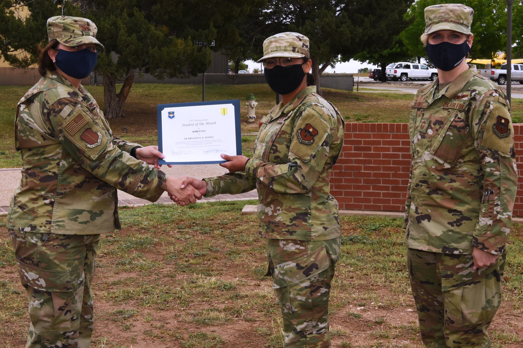 U.S. Air Force Col. Angelina Maguinness, 17th Training Group commander, presents Airman Brianna Jones, 315th Training Squadron student, the 17th TRG Student of the Month award for March 2021, outside of the Brandenburg Hall on Goodfellow Air Force Base, Texas, April 16, 2021. The 315th TRS’s mission is to train, educate, and inspire the future intelligence, surveillance, and reconnaissance warriors through innovation. (U.S. Air Force photo by Senior Airman Abbey Rieves)