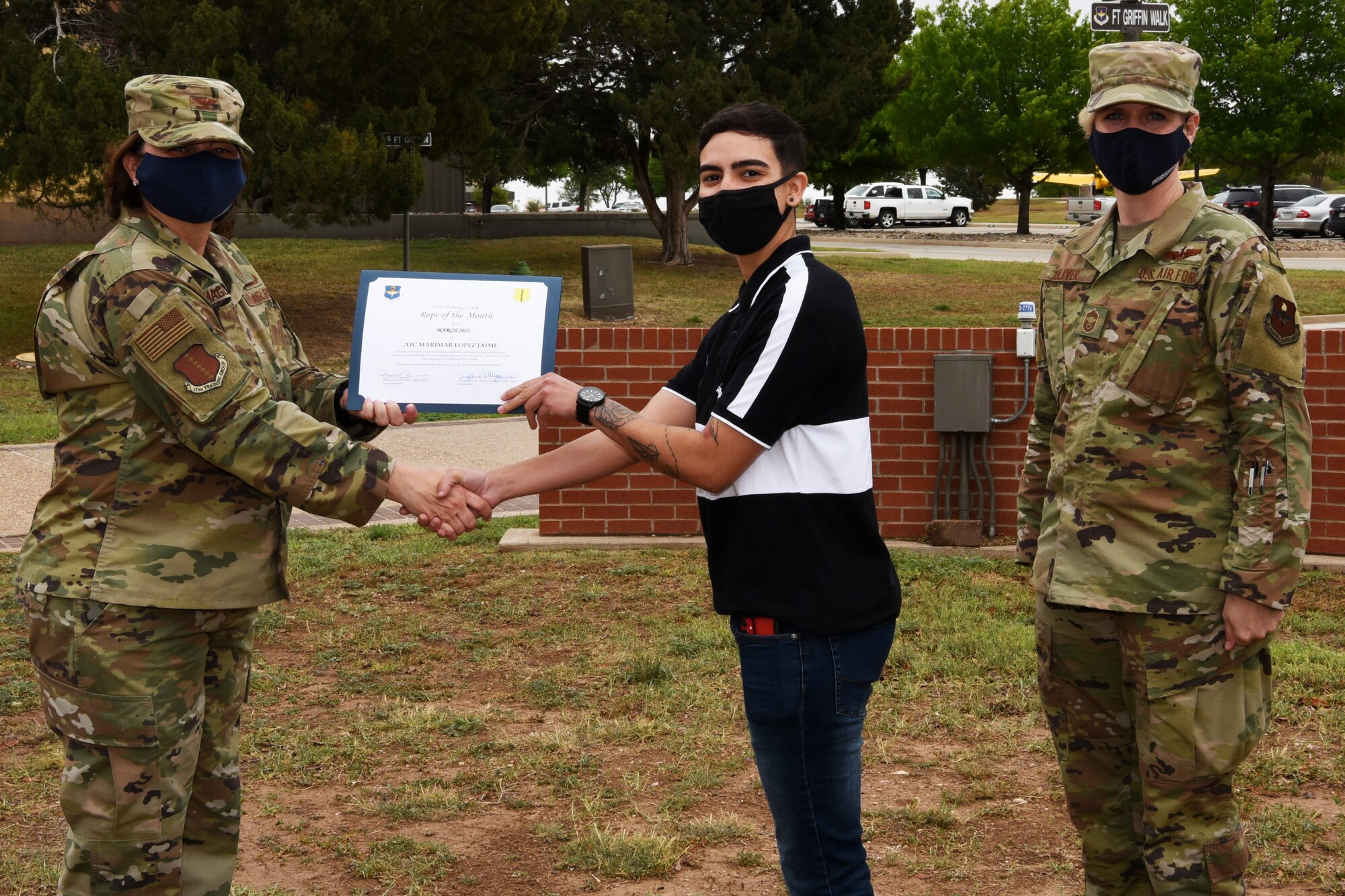 U.S. Air Force Col. Angelina Maguinness, 17th Training Group commander, presents Airman 1st Class Marimar Lopez Jaime, 316th Training Squadron student, the 17th TRG Rope of the Month award for March 2021, outside of the Brandenburg Hall on Goodfellow Air Force Base, Texas, April 16, 2021.  Military Training Leaders present different ropes to Airmen who display exceptional qualities to lead their peers. Lopez Jaime was recognized for her hard work and dedication in her rope duties. (U.S. Air Force photo by Senior Airman Abbey Rieves)