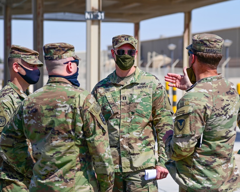 U.S. Army Capt. Stephen Long, executive officer, 401st Army Field Support Battalion-Qatar (center), listens to Col. Michael F. LaBrecque, commander, 401st Army Field Support Brigade (right) as he discusses the timeline and expectancies for complete AFSBn-Qatar deactivation, at Camp As Sayliyah, Qatar, Apr. 6.  (Photo by Capt. Luis Alani, 401st AFSB Public Affairs)