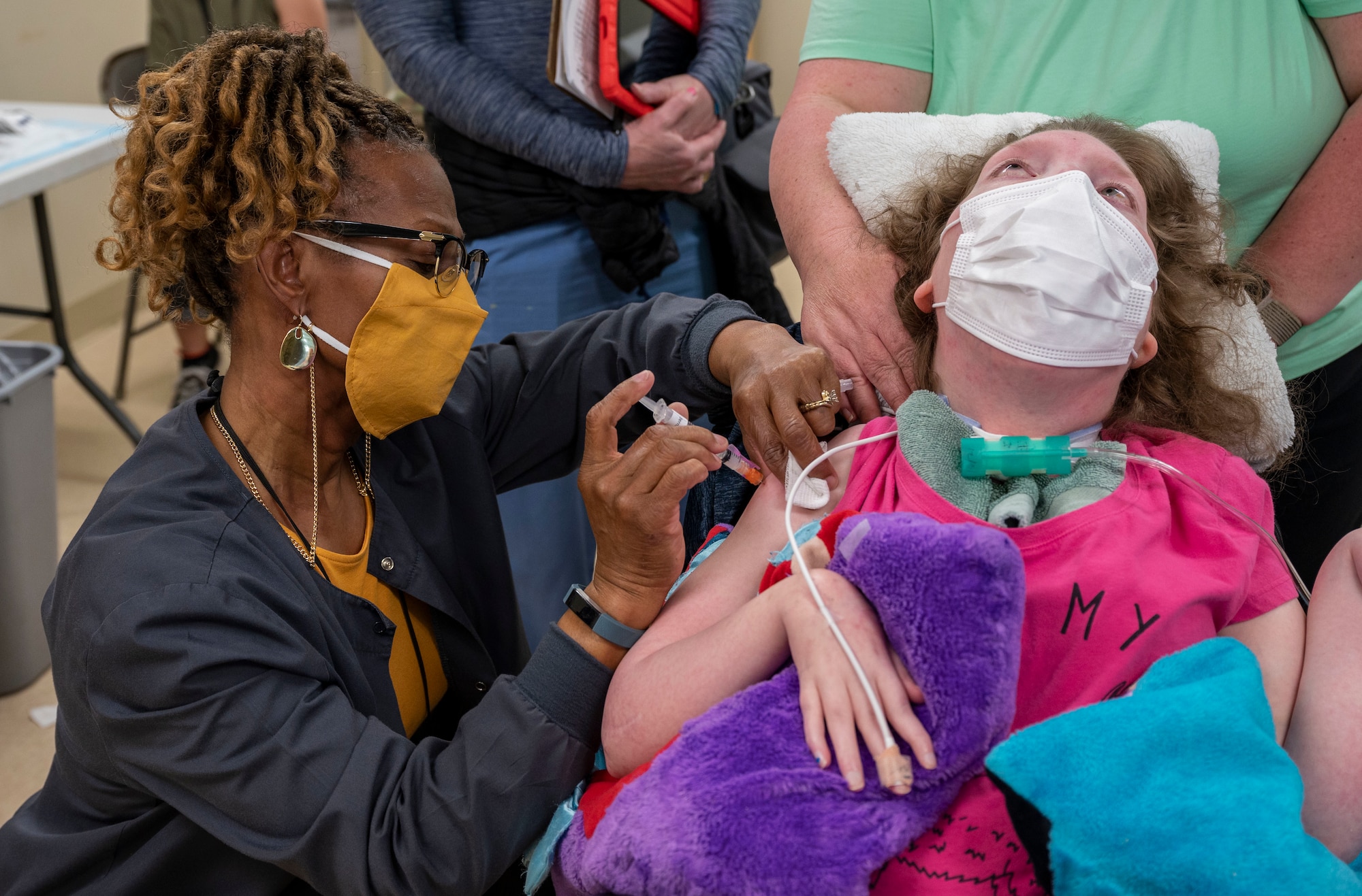 Jasmin Roy, the daughter of a retired Airman, receives her first dose of the COVID-19 vaccine from Gabriella Dillard, 436th Medical Group nurse, at Dover Air Force Base, Delaware, April 19, 2021. The 436th MDG opened vaccination eligibility to Tier 2 patients, which includes all healthy uniformed personnel and TRICARE beneficiaries. (U.S. Air Force photo by Airman 1st Class Cydney Lee)