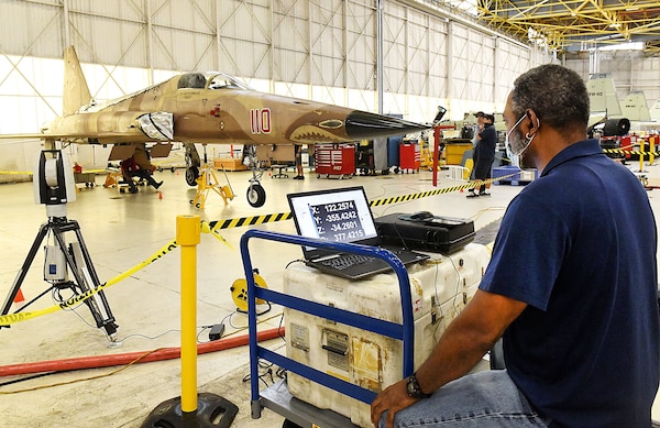 Todd Gray, a field crew machinist at Fleet Readiness Center Southeast (FRCSE), uses a laser tracker system to perform an alignment symmetry on an F-5.